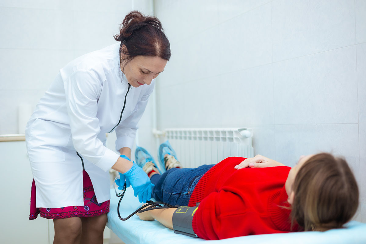 Врач меряет давление пациенту